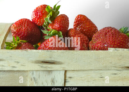 Beeren reife Erdbeere in Bast Korb für Beeren. Isolierte Bild auf weißem Hintergrund. Fotos für die Website über die Küche, Landwirtschaft, Jahreszeiten. Stockfoto