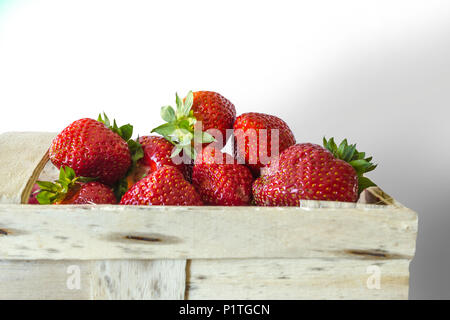 Beeren reife Erdbeere in Bast Korb für Beeren. Isolierte Bild auf weißem Hintergrund. Fotos für die Website über die Küche, Landwirtschaft, Jahreszeiten. Stockfoto