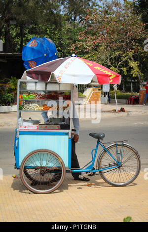 Phan Thiet, Vietnam - Januar 2014: Der Mann, der den Verkauf von Street Food Snacks von Fahrrad Markt Phan Thiet, Vietnam Abschaltdruck Stockfoto