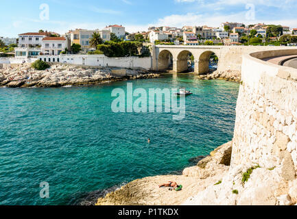 Blick auf die Bucht und die Brücke von fausse Monnaie (wörtlich "Falschgeld") in Endoume Bezirk mit Menschen beim Sonnenbaden auf den Felsen und Schwimmen in t Stockfoto