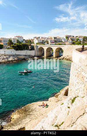 Blick auf die Bucht und die Brücke von fausse Monnaie (wörtlich "Falschgeld") in Endoume Bezirk mit Menschen beim Sonnenbaden auf den Felsen und Schwimmen in t Stockfoto