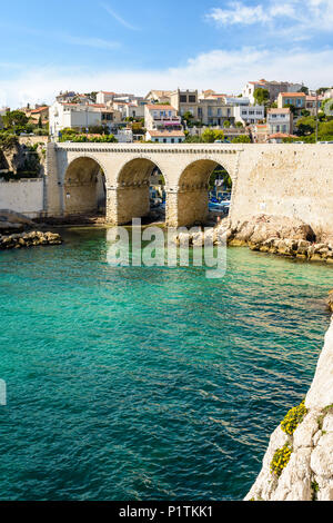 Blick auf die Bucht und die Brücke von fausse Monnaie (wörtlich "Falschgeld") in Endoume Bezirk mit Menschen beim Sonnenbaden auf den Felsen und Schwimmen in t Stockfoto