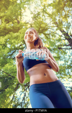 Junge fitness Frau ruht afther harten Trainings in der City Park. Von unten betrachten. Stockfoto