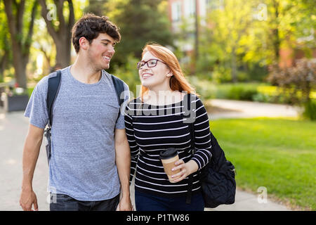 Ein junges Paar zu Fuß und Hand in Hand während man durch eine Universität Campus, Edmonton, Alberta, Kanada Stockfoto