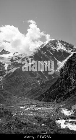 Schwarz-weiß Bild von hoher Berg mit Hütte in den Vordergrund und den Fluss führt Stockfoto