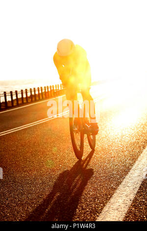 Atemberaubende am frühen Morgen Schuß eines Triathlet reiten ihr Fahrrad auf offener Straße bei einem Ironman Wettbewerb zwischen Cairns und Port Douglas Stockfoto