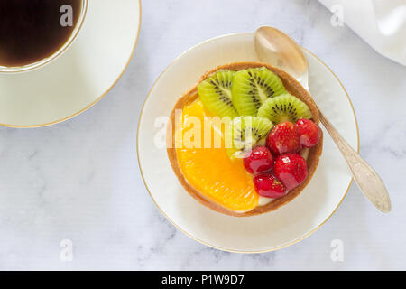 Mini Kuchen oder Torte mit Vanillesauce und verschiedene Früchte in Gelee. Selektive konzentrieren. Stockfoto