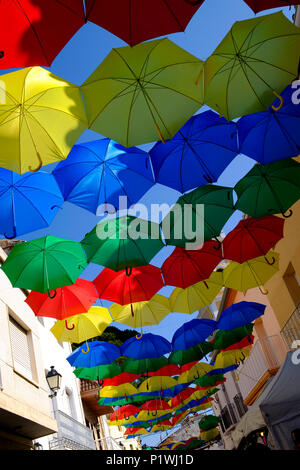 Bunte Sonnenschirme über Straßen in Spanischen Dorf während Fiesta Stockfoto