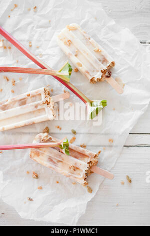 Hausgemachte Eis am Stiel mit Rhabarber, Joghurt und Müsli Stockfoto