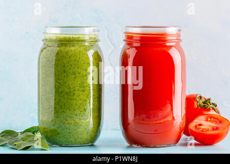 Grün/rot gefärbten Smoothies/Saft in einem Glas auf einem blauen Hintergrund. Stockfoto