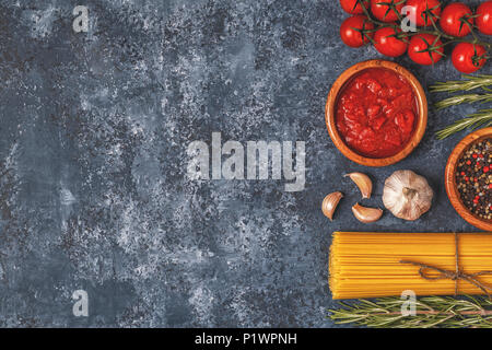 Italienische Küche mit Pasta, Gewürze und Gemüse. Ansicht von oben, kopieren. Stockfoto