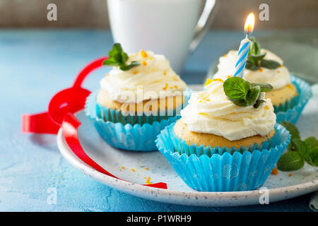 Bunte Kuchen mit Schlagsahne, Mohn und Orangenschale auf einem blauen Stein oder Schiefer Hintergrund. Stockfoto