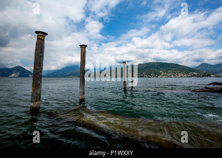 Holzsäulen und dem Ufer der Stadt Stresa auf Italienisch Lago di Maggiore mit der schönen Landschaft von Villen und Parks am See auf einem Hintergrund o Stockfoto