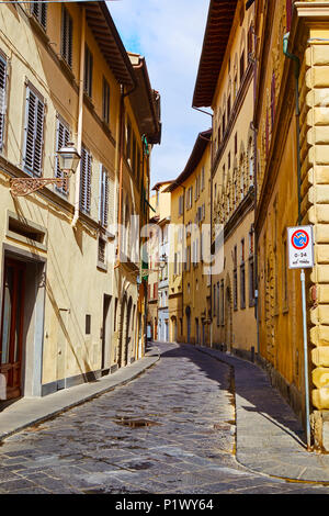 Perspektivische Ansicht der schmalen gepflasterten Straße zwischen bunten Stein alte Gebäude im Sonnenlicht, Florenz, Italien Stockfoto