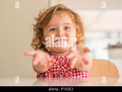 Schöne blonde Kind lächelnd Fragen für Halten, wollen Aufmerksamkeit zu Hause. Stockfoto