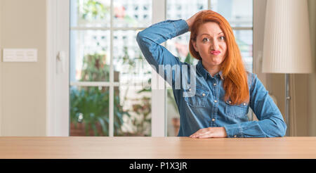 Rothaarige Frau zu Hause verwechseln und frage mich. Unsicher mit Zweifel, das Denken mit der Hand auf den Kopf. Nachdenkliches Konzept. Stockfoto