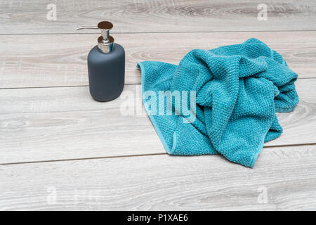 Flüssigseife und ein Handtuch auf einem Holztisch Stockfoto