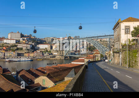 Blick auf die historische Stadt Porto mit der berühmten Brücke Ponte Dom Luis, Cable Cars und Boote auf dem Fluss Douro, Portugal Stockfoto