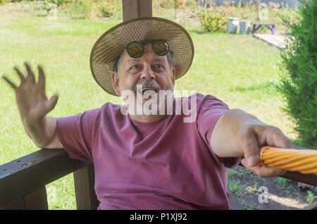 Portrait von bärtigen älteren Mann, der selfie mit Vergnügen, während er im Garten Stockfoto
