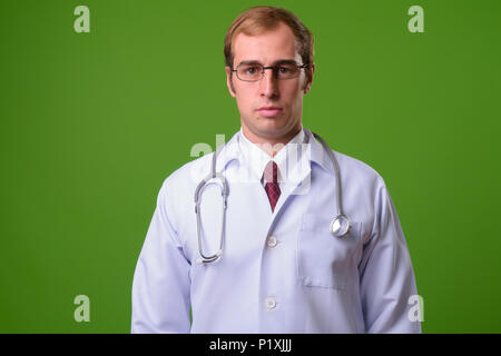 Junger Mann Arzt gegen grüner Hintergrund Stockfoto
