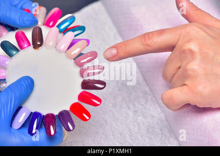 Nagelpflege und Maniküre. Nahaufnahme der Schöne weibliche Hände Anwendung transparenter Nagellack auf gesunde Nägel natürliche Frau im Beauty Salon. Manicuris Stockfoto