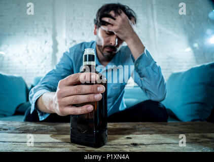 Betrunkene alkoholischen Lain business Mann trinken Whisky aus der Flasche und Glas gedrückt verschwendet und zu Hause couch in Alkoholmissbrauch und Alkoholismus co traurig Stockfoto