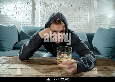 Betrunkene alkoholischen arbeitslosen Mann trinken Whisky aus dem Glas und Flasche gedrückt verschwendet und traurig zu Hause couch in Alkoholmissbrauch und Alkoholismus conce Stockfoto