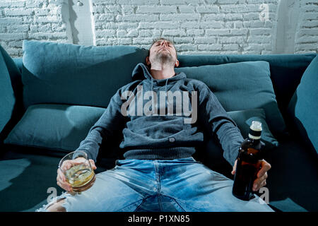 Betrunkene alkoholischen arbeitslosen Mann trinken Whisky aus dem Glas und Flasche gedrückt verschwendet und traurig zu Hause couch in Alkoholmissbrauch und Alkoholismus conce Stockfoto