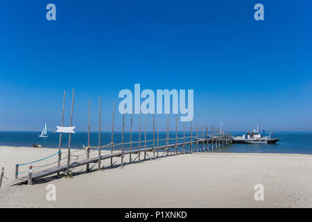 Jetty und Fähre in das blaue Wasser des Wattenmeer auf der Insel Texel in den Niederlanden Stockfoto