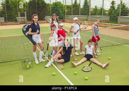 Porträt der Gruppe von Mädchen als Tennisspieler holding Tennisschläger gegen grüne Gras im Freien Gericht Stockfoto