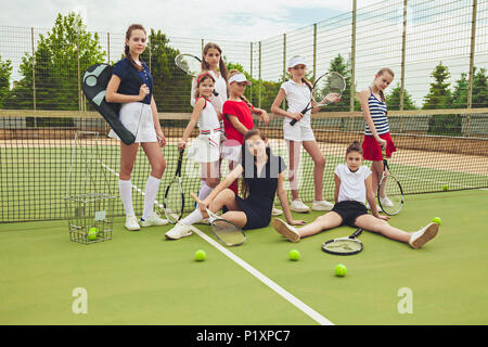 Porträt der Gruppe von Mädchen als Tennisspieler holding Tennisschläger gegen grüne Gras im Freien Gericht Stockfoto