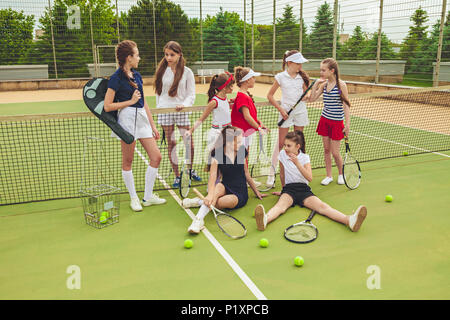 Porträt der Gruppe von Mädchen als Tennisspieler holding Tennisschläger gegen grüne Gras im Freien Gericht Stockfoto