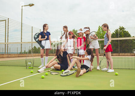 Porträt der Gruppe von Mädchen als Tennisspieler holding Tennisschläger gegen grüne Gras im Freien Gericht Stockfoto