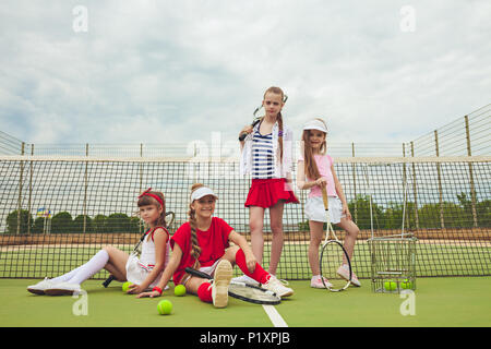 Porträt der Gruppe von Mädchen als Tennisspieler holding Tennisschläger gegen grüne Gras im Freien Gericht Stockfoto