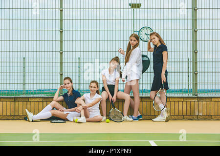 Porträt der Gruppe von Mädchen als Tennisspieler holding Tennisschläger gegen grüne Gras im Freien Gericht Stockfoto