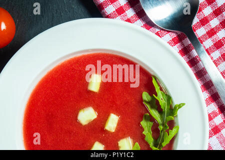 Nahaufnahme einer Platte von gazpacho Suppe mit Scheiben Tomate, Gurke und Zwiebel, mit Petersilie Stockfoto