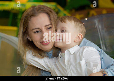 Belarus, Gomel, 6. Februar 2018. Children's Entertainment Center im SB-Warenhaus. Kinder- Urlaub. Der kleine Sohn umarmt Mom Stockfoto