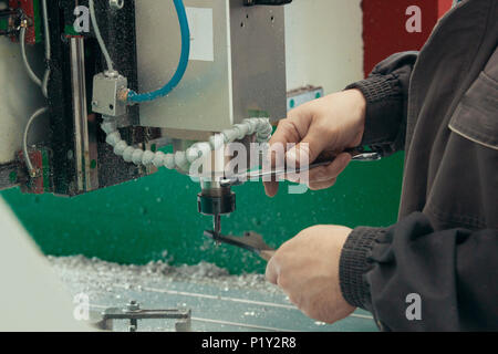 Arbeitnehmer männlichen Händen arbeiten mit CNC-Maschine im Werk mit Drehmaschinen Stockfoto