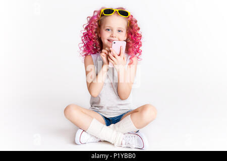 Colores wellig Krankenhausinfektionen. Ombre. Kleines, modernes Hipster girl in Mode Kleidung. Geben Sie eine Nachricht ein. Studio. Auf weiß Isoliert Stockfoto