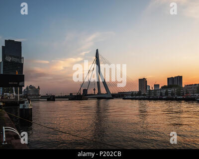 ROTTERDAM, Niederlande - 31. MAI 2018: Erasmus Brücke an der Maas mit der De Rotterdam Türme im Hintergrund nach Sonnenuntergang. Stockfoto