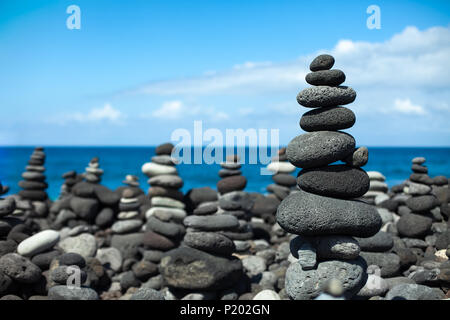 Steine Pyramiden am Kiesstrand in Teneriffa, Kanarische Inseln, Spanien. Konzept der Harmonie und Balance Stockfoto