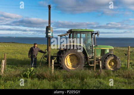 dh Posts Zaun Rammmaschine LANDWIRTSCHAFT UK Traktor Feld Rammmaschine Landwirt Betrieb Post Rammer Barbwire Zäune hydraulischen RAM Menschen Stockfoto