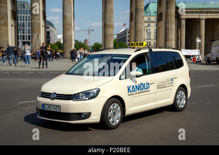 BERLIN, DEUTSCHLAND - 28. APRIL 2018: Deutscher Taxi fahren vorbei am Brandenburger Tor. Stockfoto