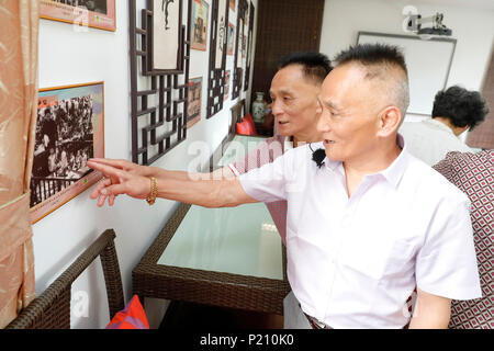 Shanghai, China. 12 Juni, 2018. Zhang Gongqiang (vorne) und Zhang Ziqiang (L) Blick auf ihre Kindheit Foto bei der China Welfare Institut (CWI) Baumschule in Shanghai, China, 12. Juni 2018 ausgestellt. In dieses Jahr fällt der 80. Jahrestag der CWI, von Soong Ching Ling wurde 1938 gegründet. Die Shanghai Organisation konzentriert sich auf die Gesundheit von Mutter und Kind, Bildung und soziale Wohlfahrt. Soong Ching Ling, in Shanghai im Jahr 1893 geboren, war die Frau von der chinesischen revolutionären Dr. Sun Yat-sen, der die Revolution 1911 führte. Credit: Gao Feng/Xinhua/Alamy leben Nachrichten Stockfoto