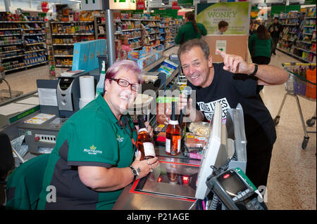 Liebe Supermarkt Sänger Geoff Davis, von Falmouth, Cornwall, Pläne in jedem Morrisons Stores in Großbritannien zu singen. Geoff, der Geld für das CLIC Sargent Liebe setzte seine Supermarkt Tour mit dem Besuch der Morrisons Stores in Wick, Littlehampton, West Sussex, England. Geoff will helfen, Geld für die Liebe nach seinem Sohn verlieren zu Krebs vor 43 Jahren und hat bisher über 20.000 £ angehoben und besuchte 40 Geschäften in ganz Großbritannien. Auf dem Foto: Geoff singt sie mit einem Mitarbeiter. Credit: Scott Ramsey/Alamy leben Nachrichten Stockfoto