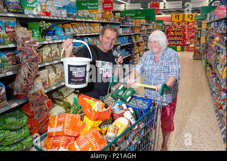 Liebe Supermarkt Sänger Geoff Davis, von Falmouth, Cornwall, Pläne in jedem Morrisons Stores in Großbritannien zu singen. Geoff, der Geld für das CLIC Sargent Liebe setzte seine Supermarkt Tour mit dem Besuch der Morrisons Stores in Wick, Littlehampton, West Sussex, England. Geoff will helfen, Geld für die Liebe nach seinem Sohn verlieren zu Krebs vor 43 Jahren und hat bisher über 20.000 £ angehoben und besuchte 40 Geschäften in ganz Großbritannien. Auf dem Foto: Geoff singt an einen Kunden. Credit: Scott Ramsey/Alamy leben Nachrichten Stockfoto