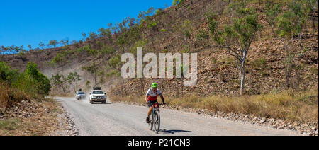 Gibb Herausforderung 2018 Radfahrer reiten Mountainbike und 4 wheel drive Support Fahrzeuge auf einer Schotterstraße El Questro Station Kimberley WesternAustralia Stockfoto