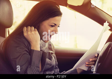 Junge aufgeregt Frau in new car Lesen von Dokumenten. Transport und Ownership Konzept. Stockfoto