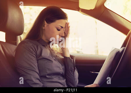 Betonte Frau Treiber mit Papieren in Ihrem Auto sitzen Stockfoto