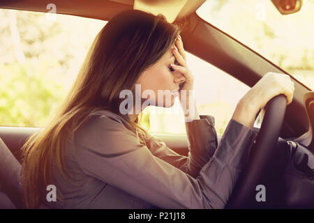 Betonte Frau Fahrer sitzt in ihrem Auto Stockfoto